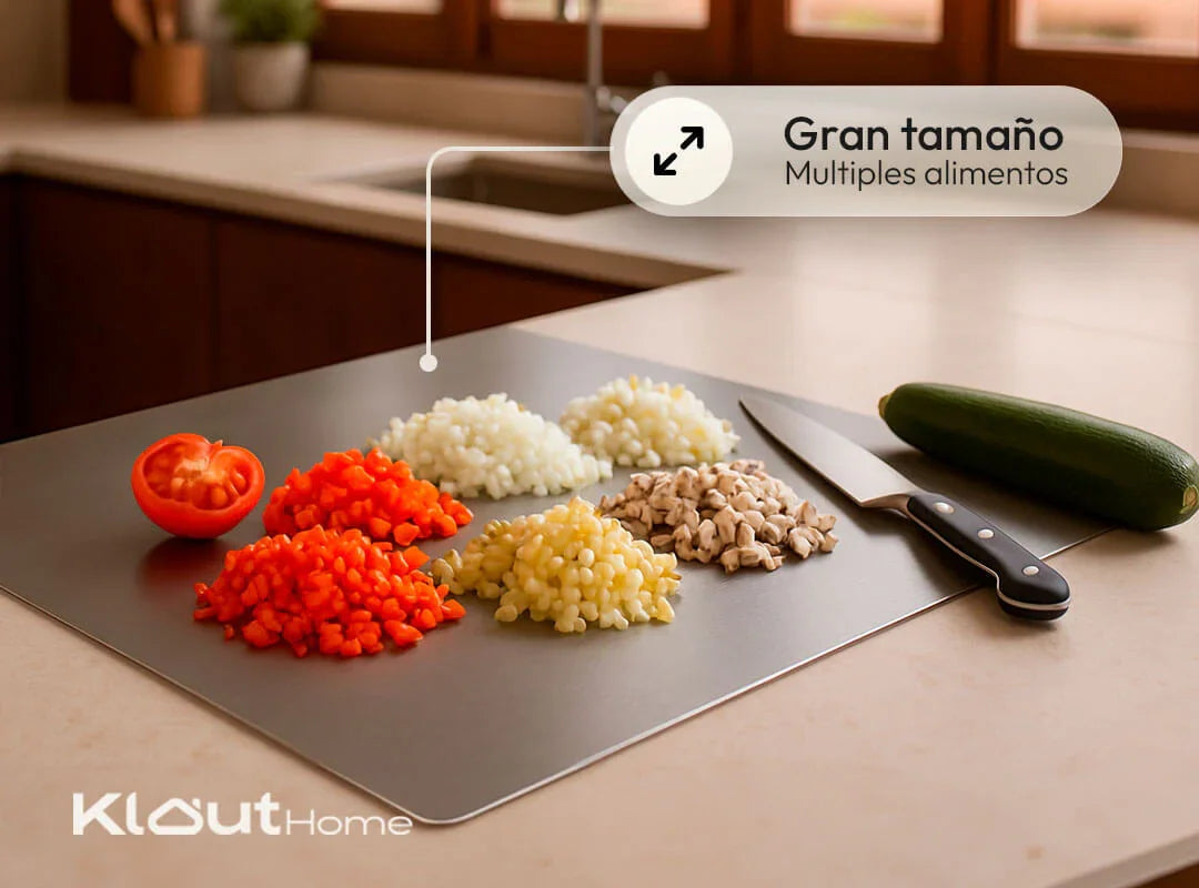 Tabla de cortar grande con verduras picadas, cuchillo y calabacín en cocina moderna.